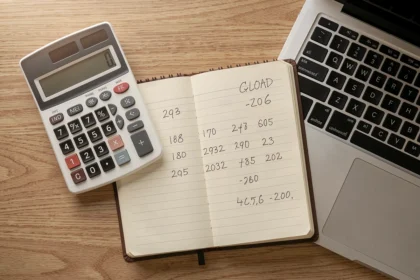 Bureau avec calculatrice, carnet de comptes et ordinateur portable