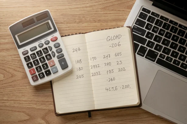 Bureau avec calculatrice, carnet de comptes et ordinateur portable