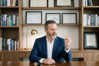 Homme d'affaires en costume examinant une barre d'or