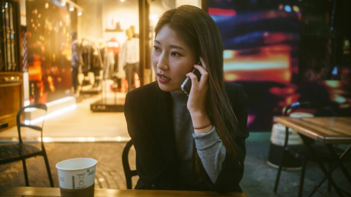 woman talking on phone outdoor in front of store